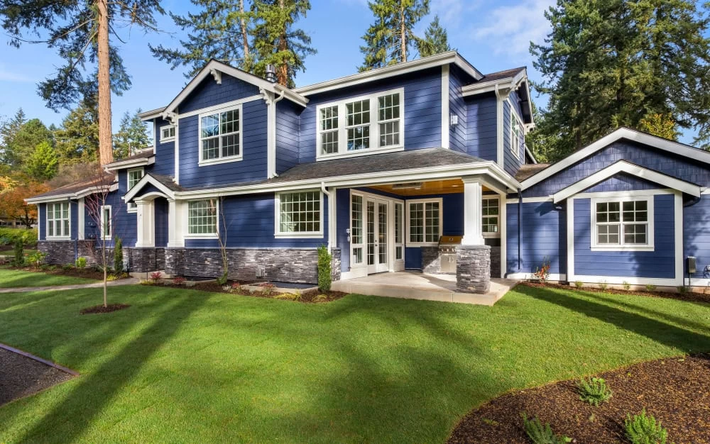 Blue house with large yard and trees after home remodeling in Contra Costa County