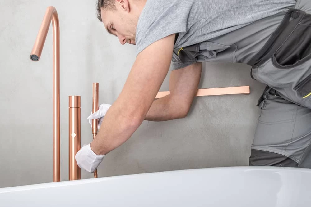 Man fixing copper bathtub during home remodeling in Contra Costa County