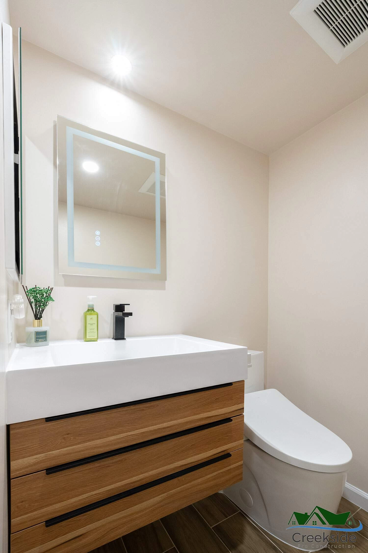 A shower with a glass door and shelves.
